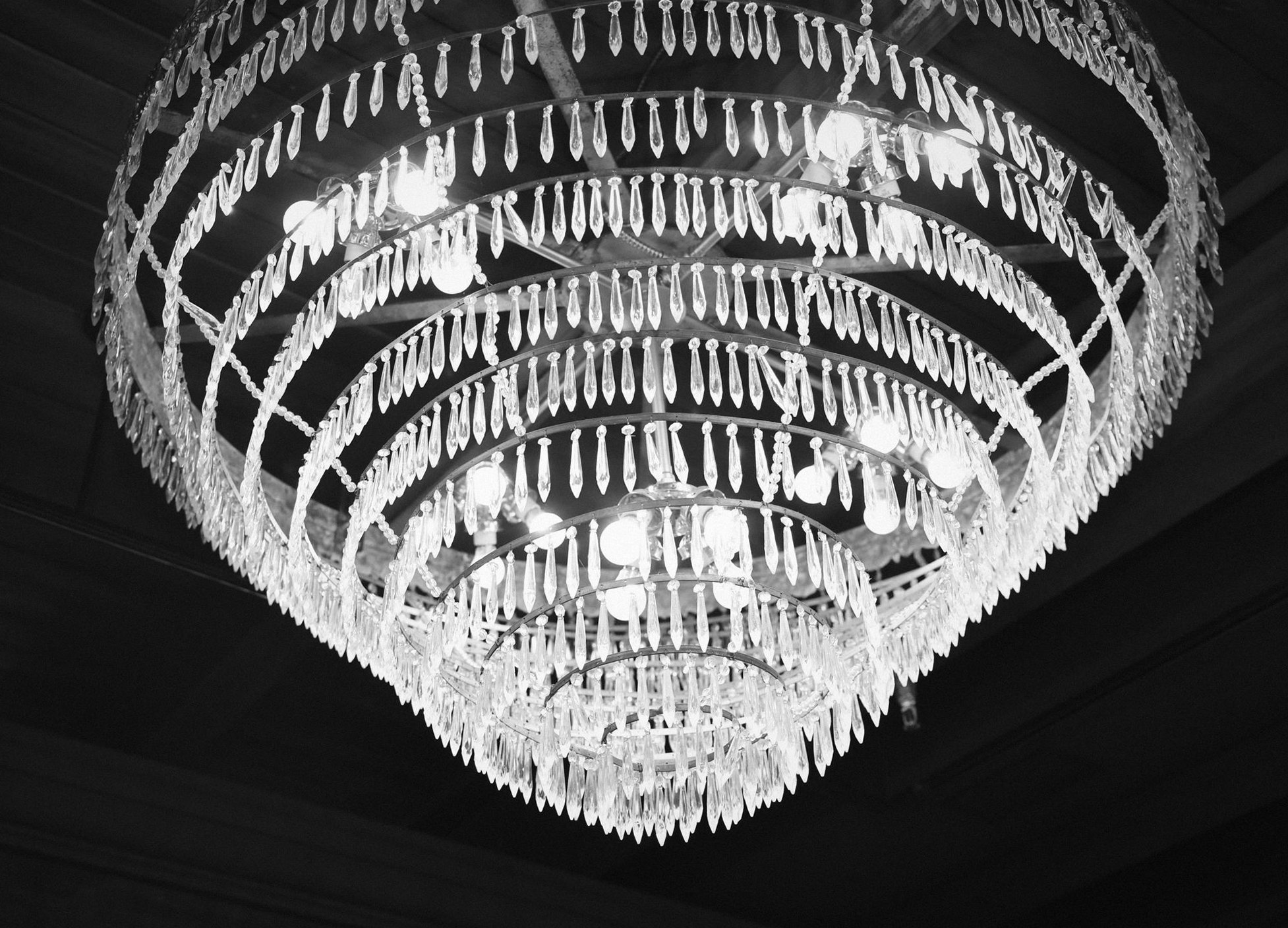 Tiered crystal chandelier glowing against a dark ceiling