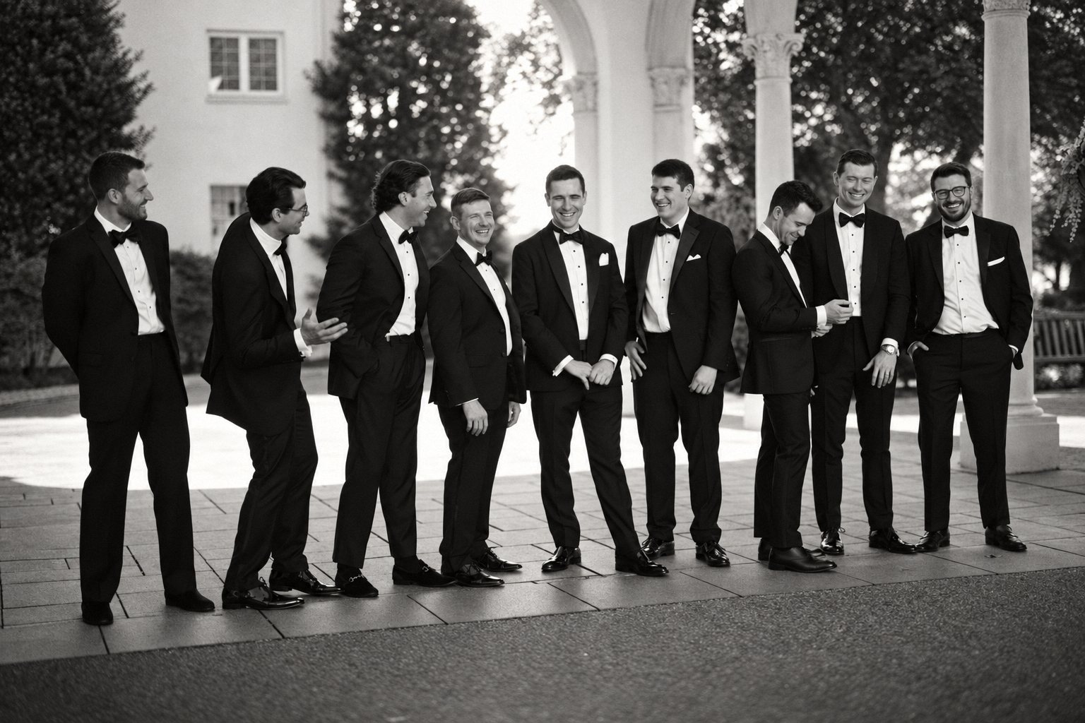 Black and white portrait of groomsmen laughing in tuxedos