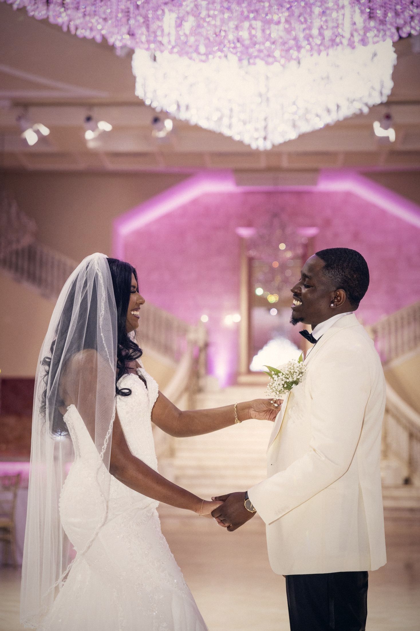 Couple holding hands under a crystal chandelier