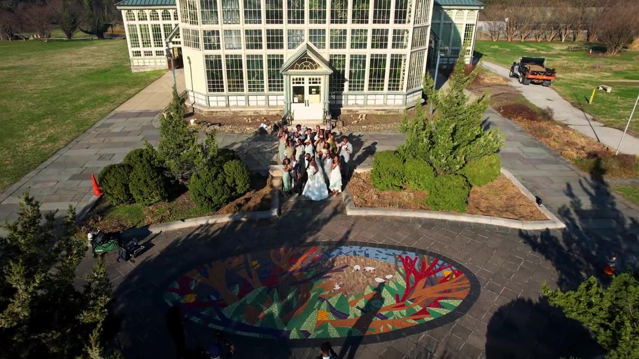 Aerial view of a wedding party outside a glass conservatory