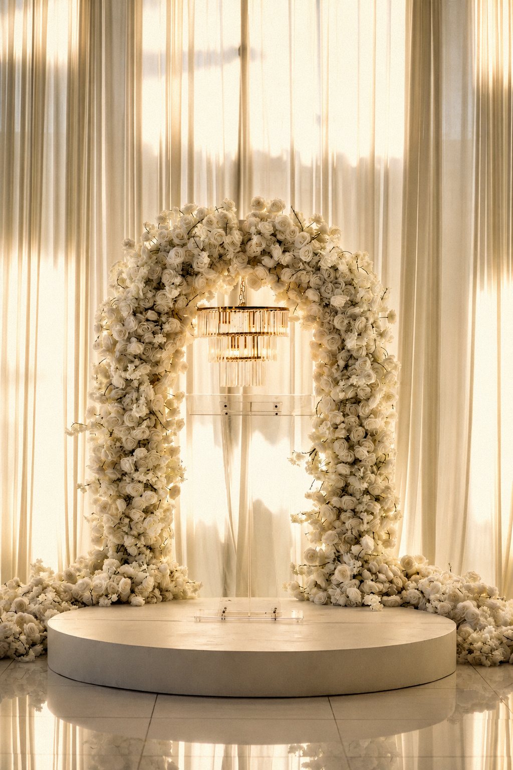 White rose ceremony arch with a crystal chandelier