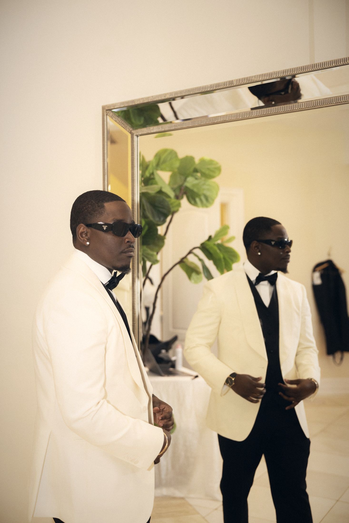 Groom in a white dinner jacket and sunglasses at the mirror