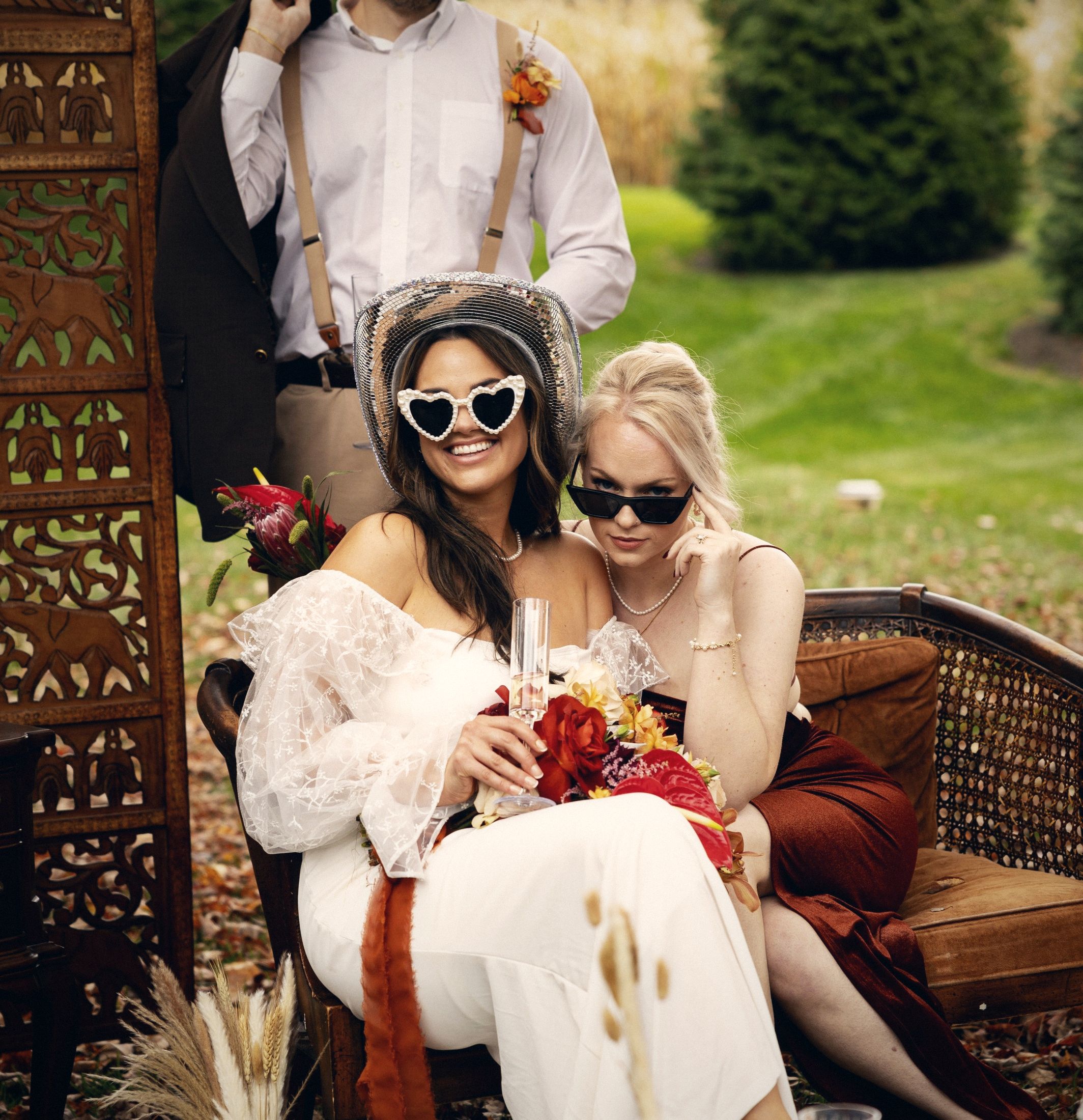 Bride and bridesmaid posing in heart sunglasses