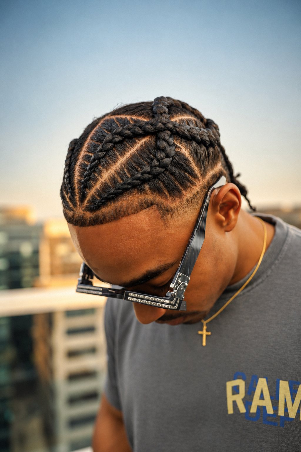 Overhead detail of braided hair, sunglasses, and a gold cross