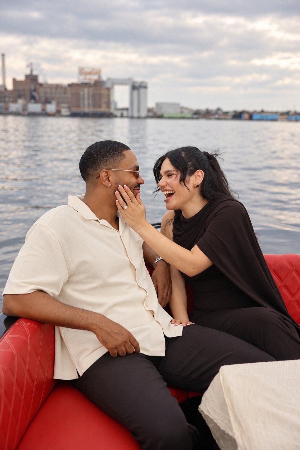 Couple laughing on the boat with the Domino Sugars sign behind them