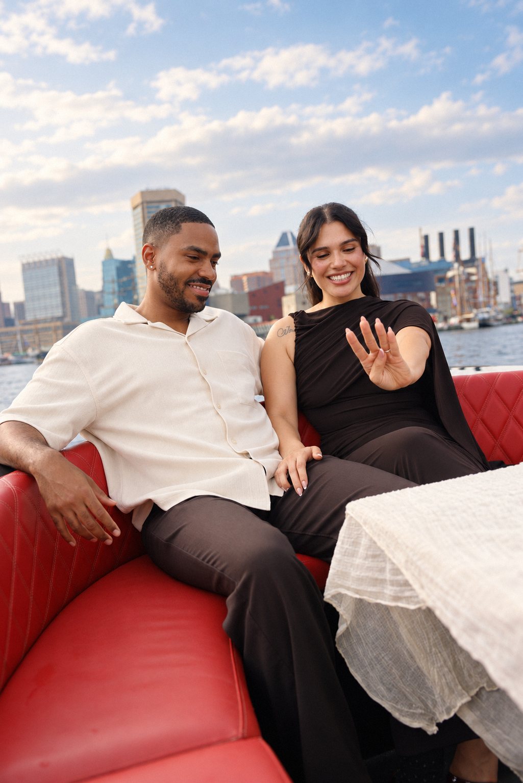 Couple admiring the engagement ring with the Baltimore skyline behind