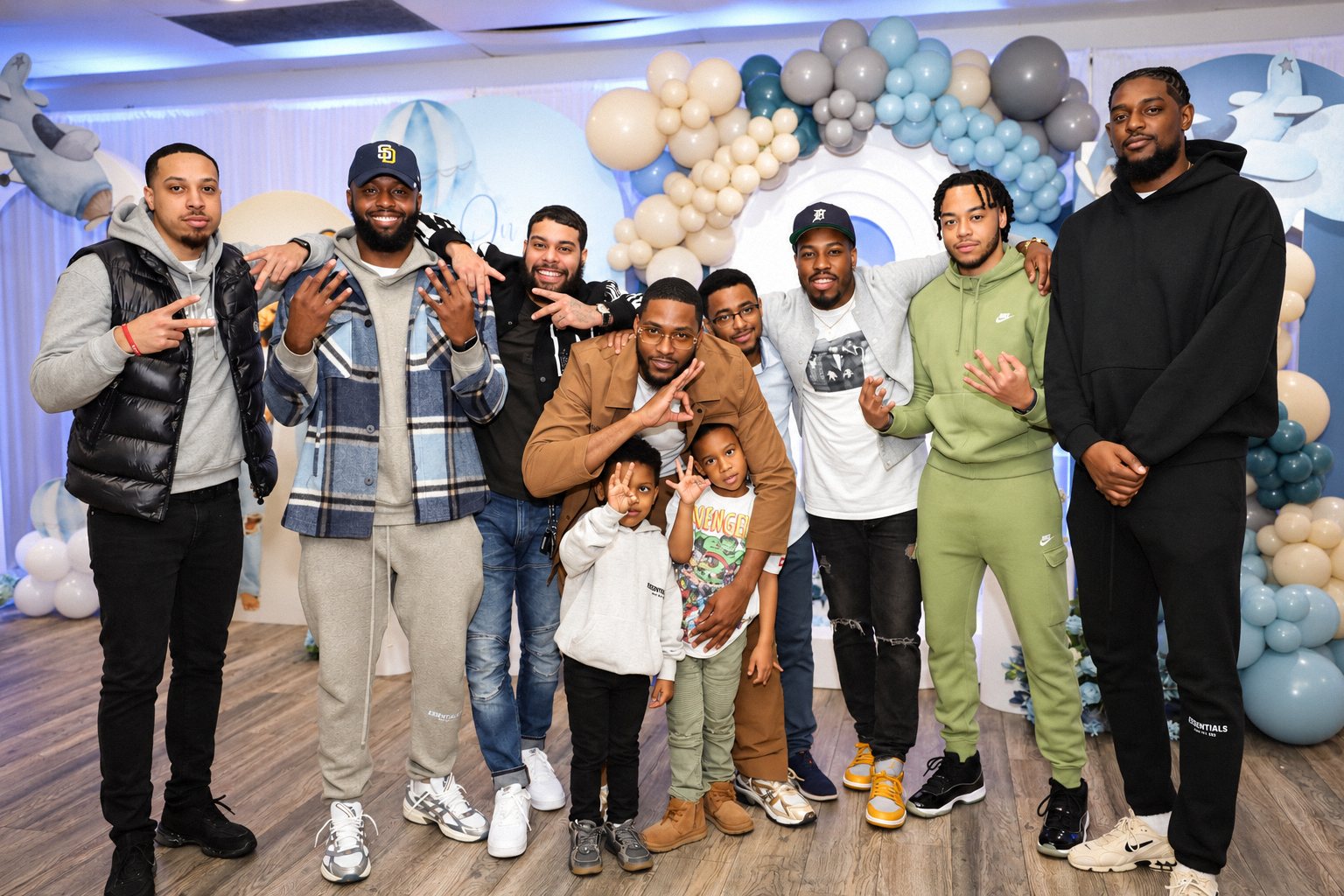 Friends posing in front of a balloon backdrop at a baby shower