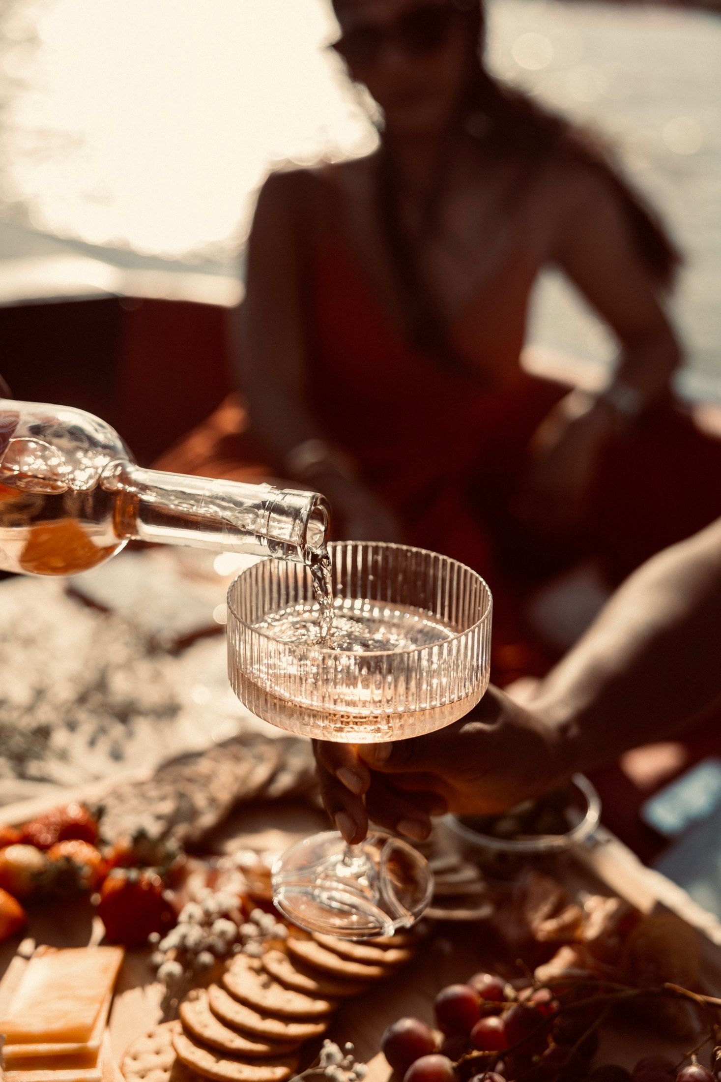 Rosé poured into a ribbed coupe over a charcuterie board