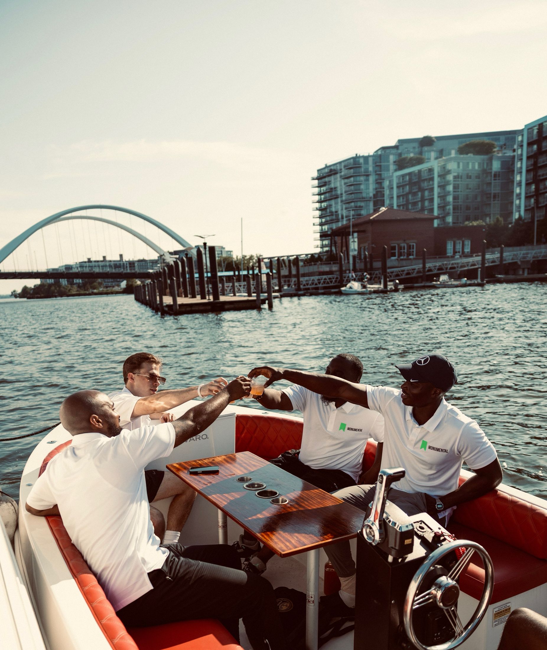 Four men toasting on a private boat at the Navy Yard